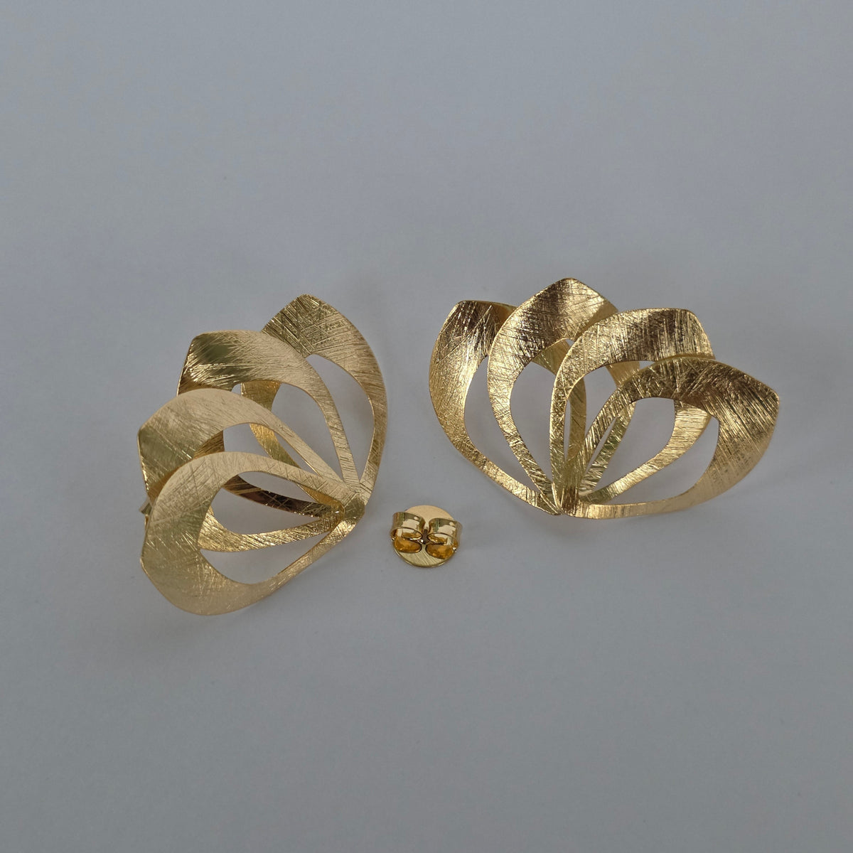 Aretes Topo Pétalos Entrelazados Textura Satinada – Baño de Oro 18K — Joyería BomLeón