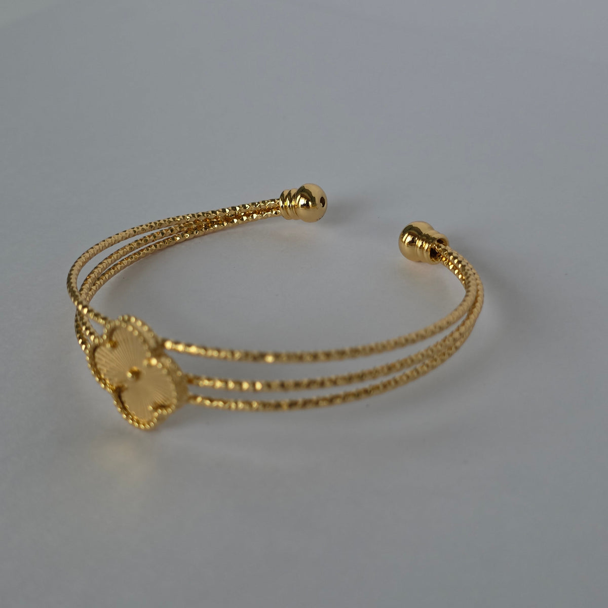 Pulsera Cuff Triple Hilo Texturizado con Trébol Central – Baño de Oro 18K — Joyería BomLeón
